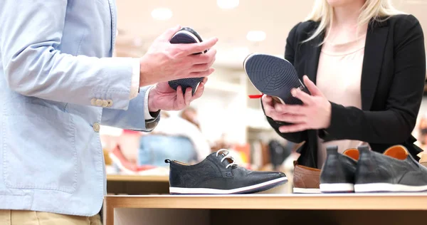 Homem escolhe sapatos na loja de sapatos — Fotografia de Stock