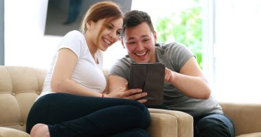 Evde dijital tablet kullanan genç çift