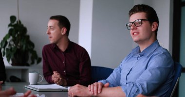 Bir grup iş adamı ofiste iş planlarını tartışıyor.