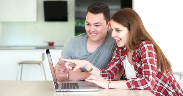 Пара с помощью ноутбука, чтобы магазин в Интернете в современной квартире — стоковое фото