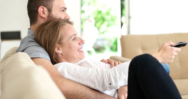 Senioren-Paar vor Fernseher in moderner Villa — Stockfoto