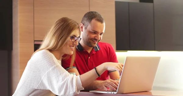 Pareja usando el ordenador portátil para comprar en línea en apartamento moderno — Foto de Stock