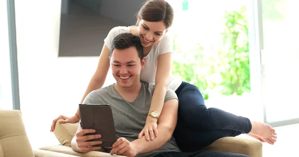 家中使用数码平板电脑的年轻夫妇 — 图库照片