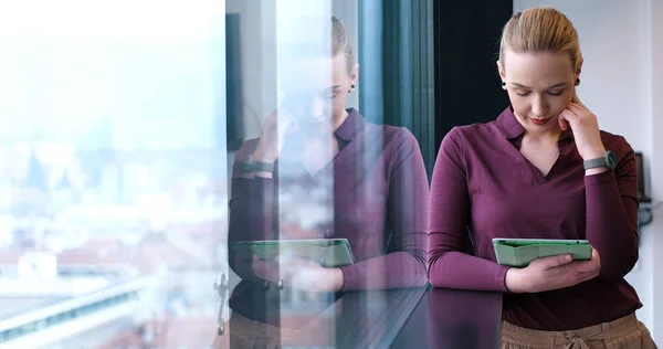 Mooie zakenvrouw met behulp van Tablet In kantoorgebouw door raam — Stockfoto