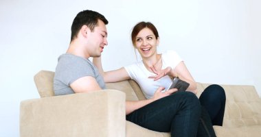 Evde dijital tablet kullanan genç çift