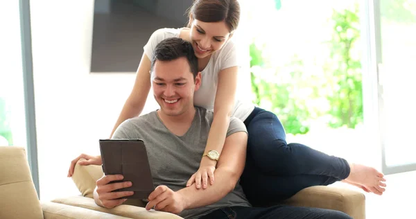 Νεαρό ζευγάρι που χρησιμοποιεί ψηφιακό tablet στο σπίτι — Φωτογραφία Αρχείου
