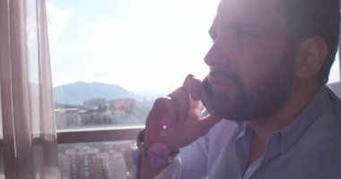 Evde cep telefonuyla konuşan iş adam