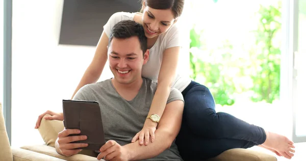 Jovem casal usando tablet digital em casa — Fotografia de Stock