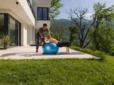 kadın ve kişisel antrenör egzersiz pilates topu ile yapmak