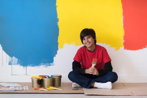 Jeune garçon peintre se reposant après avoir peint le mur — Photo