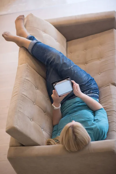 Жінка на дивані за допомогою планшетного комп'ютера — стокове фото