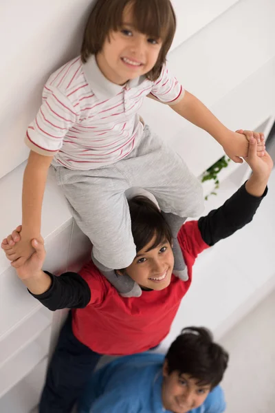 Jeunes garçons posant ligne jusqu'à piggyback vue de dessus — Photo