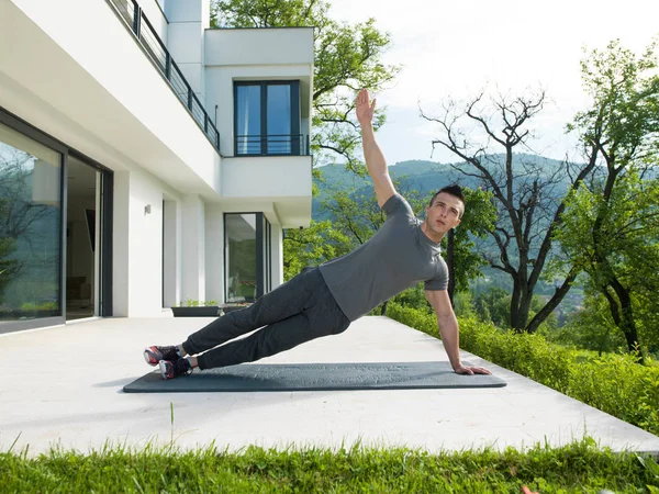 Hombre haciendo ejercicios de yoga por la mañana — Foto de Stock