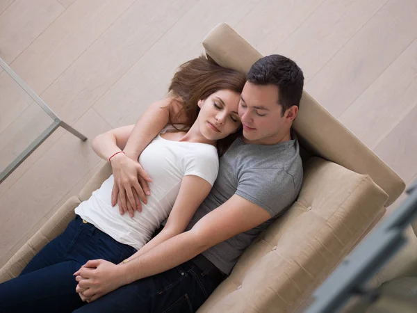 Jovem casal bonito abraçando no sofá — Fotografia de Stock