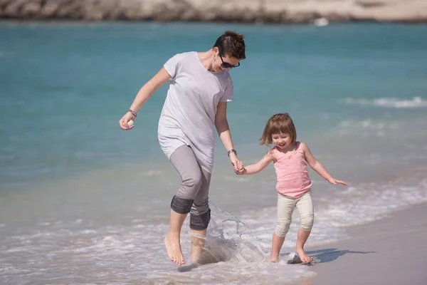 Mutter und Tochter rennen am Strand — Stockfoto