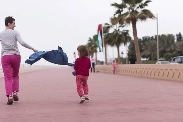 Mutter und süßes kleines Mädchen auf der Promenade am Meer — Stockfoto