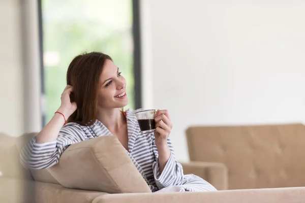 Jonge vrouw in een badjas genieten van koffie in de ochtend — Stockfoto