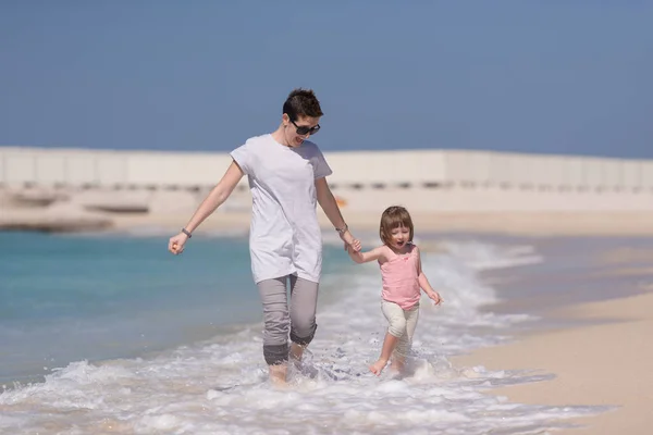 Mutter und Tochter rennen am Strand — Stockfoto