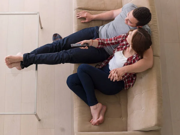Junges Paar auf dem Sofa vor dem Fernseher — Stockfoto