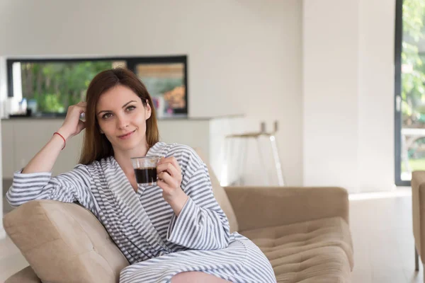 バスローブ姿で朝のコーヒーを楽しんでいる若い女性 — ストック写真
