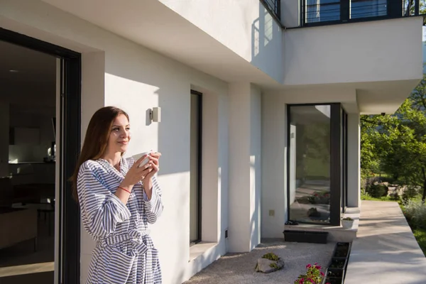 Vrouw in een badjas genieten van koffie in de ochtend — Stockfoto