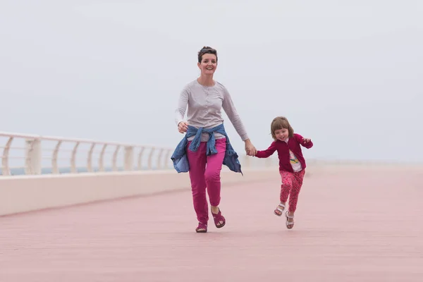 Mère et jolie petite fille sur la promenade au bord de la mer — Photo