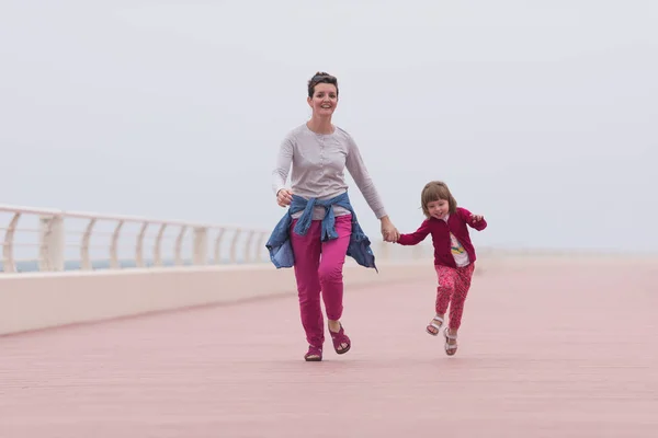 Moeder en schattig klein meisje op de promenade aan de zee — Stockfoto