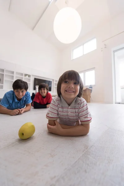Jongens met plezier met een appel op de verdieping — Stockfoto