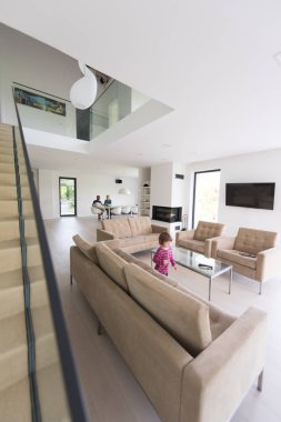 küçük kız ailesiyle modern oturma odasında sahiptir
