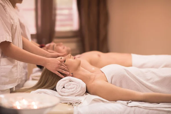 Casal desfrutando de massagem na cabeça no spa — Fotografia de Stock