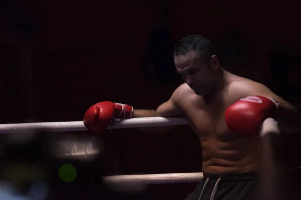 Kickboxer descansando sobre las cuerdas en la esquina — Foto de Stock