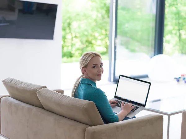 Ung kvinna som använder laptop hemma — Stockfoto