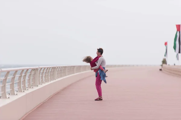 Mutter und süßes kleines Mädchen auf der Promenade am Meer — Stockfoto