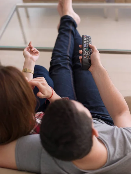 Pareja joven en el sofá viendo la televisión —  Fotos de Stock