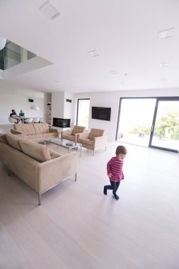 küçük kız ailesiyle modern oturma odasında sahiptir