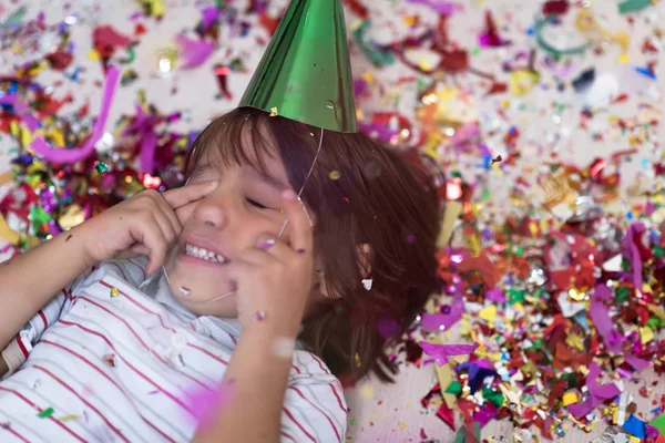 Niño Feliz Celebrando Fiesta Con Confeti Mientras Está Tirado Suelo —  Fotos de Stock