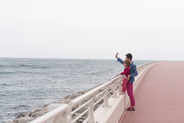 Anne ve Promenade denizin kenarında sevimli küçük kız — Stok fotoğraf