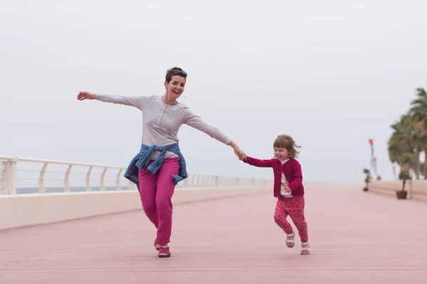 Mutter und süßes kleines Mädchen auf der Promenade am Meer — Stockfoto