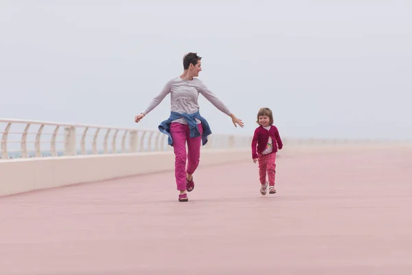 Mutter und süßes kleines Mädchen auf der Promenade am Meer — Stockfoto