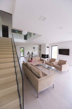 küçük kız ailesiyle modern oturma odasında sahiptir