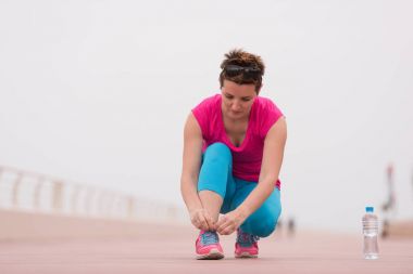 genç kadın üzerinde spor ayakkabı ayakkabı bağcığı bağlama