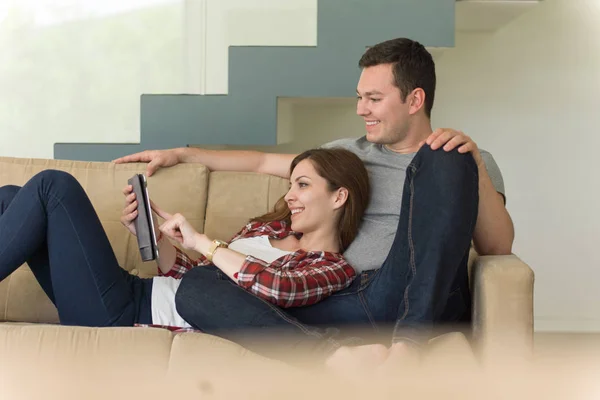 Pareja relajante en casa con tabletas — Foto de Stock