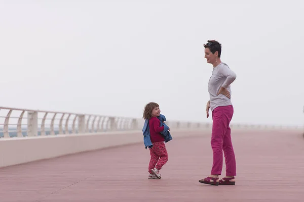 Mère et jolie petite fille sur la promenade au bord de la mer — Photo