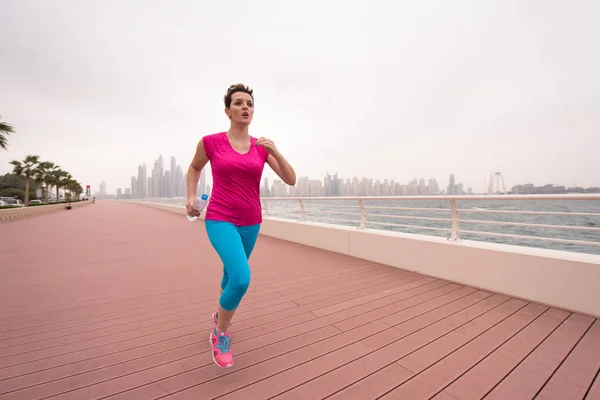 Mujer corriendo en el paseo marítimo — Foto de Stock