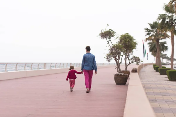 Mor och söt liten flicka på strandpromenaden vid havet — Stockfoto