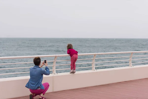 Mutter und süßes kleines Mädchen auf der Promenade am Meer — Stockfoto