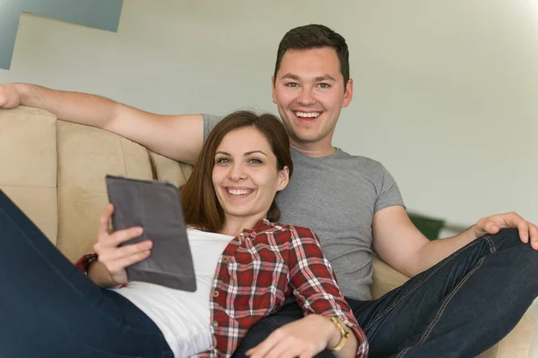 Couple relaxant à la maison avec tablettes — Photo