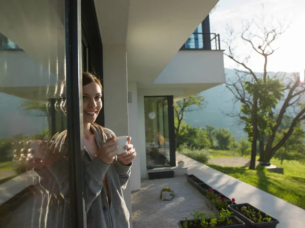 Femme buvant du café devant sa maison de luxe — Photo