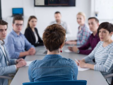 Bir grup iş adamı ofiste iş planlarını tartışıyor.