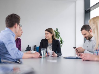 Bir grup iş adamı ofiste iş planlarını tartışıyor.